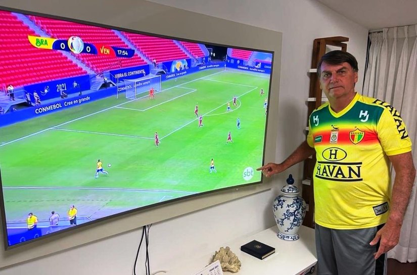 Bolsonaro vê Brasil na Copa América e tira foto apontando para logo do SBT