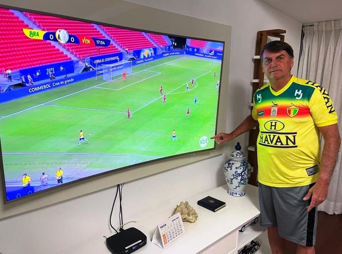 Bolsonaro vê Brasil na Copa América e tira foto apontando para logo do SBT